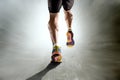 Strong athletic legs with ripped calf muscle of sport man running on motion grunge background