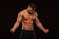 Strong Athletic Man Fitness Model Torso showing six pack abs. isolated on black background with copyspace is looking at Royalty Free Stock Photo