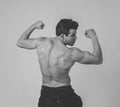Young fitness muscly man showing his back,shoulders, triceps and biceps muscles after training Royalty Free Stock Photo