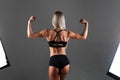 Strong Athletic woman Fitness Model posing back muscles, triceps, latissimus over black background. Studio Shooting