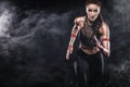 A strong athletic, woman sprinter, running on black background wearing in the sportswear, fitness and sport motivation Royalty Free Stock Photo