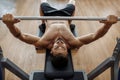 Strong athletic young man bodybuilder fitness model exercise chest with barbell on the bench in gym. Top view.