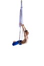 Strong, athletic young man, professional aerial gymnast, acrobat training with aerial tissues against white studio