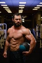 strong bearded man with medicine ball in fitness sport gym at night