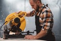 Strong bearded mechanic working on electrical angular grinding machine in metalworking factory. Work in service station