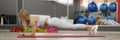 Strong beautiful girl in sportswear doing plank exercise closeup