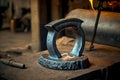 strong blacksmith processes metal product in shape of ring on anvil