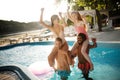 Strong boyfriends holding their girlfriends while chilling in pool