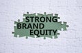 Strong Brand Equity symbol. Concept words Strong Brand Equity on white puzzle. Beautiful grey green background. Business and Royalty Free Stock Photo