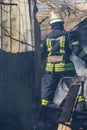 A strong and brave fireman rescues a burning building using water in a fire operation. Fireman in a fire protection suit.