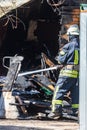 A strong and brave fireman rescues a burning building using water in a fire operation. Fireman in a fire protection suit.