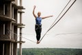 Strong and brave young woman balancing on a slackline