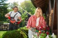 Man pruning bushes while woman taking care of flowers Royalty Free Stock Photo