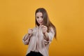 Strong caucasian woman in fashion pastel shirt showing fists, ready for fight