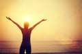 Strong confident woman open arms sunrise seaside