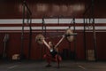 Strong crossfit woman doing squats with barbell overhead. Fit young woman lifting heavy weights