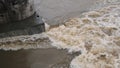 Strong current of water in the river during the spring flood near the bridge support