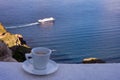 Strong delicious coffee in a white cup with a saucer against the backdrop of the sea and a floating liner. Great start to the day.