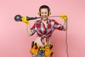 Strong energy handyman woman in yellow gloves, noise insulated headphones, kit tools belt full of instruments holding