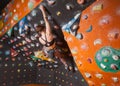 Strong female climber on boulder climbing wall indoor Royalty Free Stock Photo