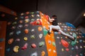 Strong female climber on boulder climbing wall indoor Royalty Free Stock Photo