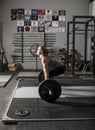 Strong female weight lifter preparing for deadlift in gym
