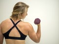 Strong female woman doing bicep curls for exercise at the gym