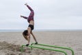 Strong fitness young female doing hand stand push ups exercise in parallel bars on beach.Athletic sportswoman during workout in Royalty Free Stock Photo