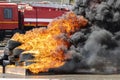 Strong flames from burning car tires on background of a fire truck. firefighters training Royalty Free Stock Photo