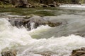 Strong flow and boiling of water in mountain river with splashes Royalty Free Stock Photo