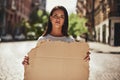 Strong and free. Young woman with word freedom written on her body holding a blank banner while standing on the road Royalty Free Stock Photo