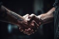 Strong friendly partnership business handshake of two male hands, dark background isolate.