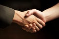 Strong friendly partnership business handshake of two male hands, dark background isolate.