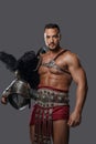 Gladiator in lightweight historical armor against grey studio background