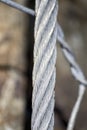 Strong grey steel cable with rock in the background