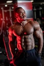 Strong halfnaked african american bodybuilder standing in contemporary gym and looking away. Royalty Free Stock Photo