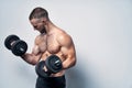 Strong sport sirtless man making weightlifting with dumbbells