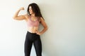 Fit young woman showing off her arm muscles and smiling Royalty Free Stock Photo