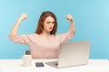 Strong independent confident woman boss raising hands showing biceps when talking on video call, looking proud