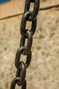 Strong iron chain links in front of stone wall Royalty Free Stock Photo