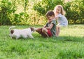 Happy smiling children playing tug-of-war game with their stubborn pet dog Royalty Free Stock Photo