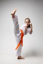 Strong kick in a karate workout, a child girl in a kimono Royalty Free Stock Photo