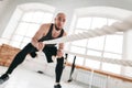 Strong male athlete doing exercises with rope at crossfit gym