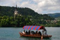 A strong male boat rower enjoy rowing a boat for tourists on Lake Bled with very colourful cover