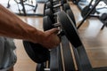 Strong male hand lifting a dumbbell in a sports studio. Athletic young man trains in the gym. Close-up of a man`s hand Royalty Free Stock Photo