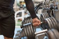 Strong male hand lifting a dumbbell in a sports studio. Athletic young man trains in the gym. Royalty Free Stock Photo