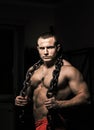Strong male poses holding steel chain