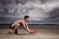 Strong male with red ball on the beach Royalty Free Stock Photo