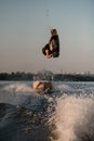 strong man makes dangerous stunts jumping and flips on wakeboard over splashing wave Royalty Free Stock Photo