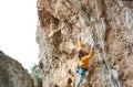 Strong man climber climbing on the rock route, making hard wide move and cliping rope Royalty Free Stock Photo